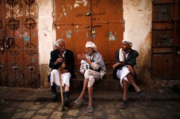 People chat as they sit at a marketplace in the Old Sanaa city